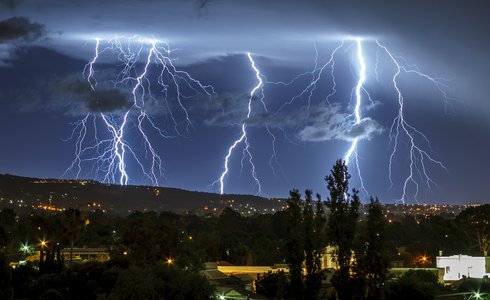 Langzeitbelichtung Gewitter bei Nacht über ländlicher Gegend, hügelig